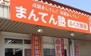 ふくだ教室の外観。「まんてん塾 ふくだ教室」と書かれた大きなオレンジ色の看板